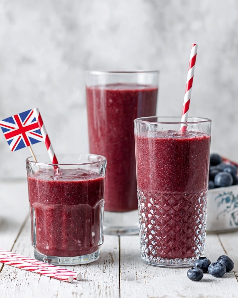 The image shows three clear glasses filled with a thick, deep reddish-purple smoothie with tiny dark specks throughout. The tallest glass is in the front center, the medium glass is to its left, and a shorter glass with a raised dotted pattern is at the back right, each filled nearly to the top. Two red-and-white striped paper straws stand upright in the tallest and the dotted glasses. Around the glasses, there are a few scattered blueberries and a small white flag with a red and blue design. The glasses sit on a white wooden surface with a white marbled texture background behind them. photo taken with an iphone --ar 4:5 --v 7