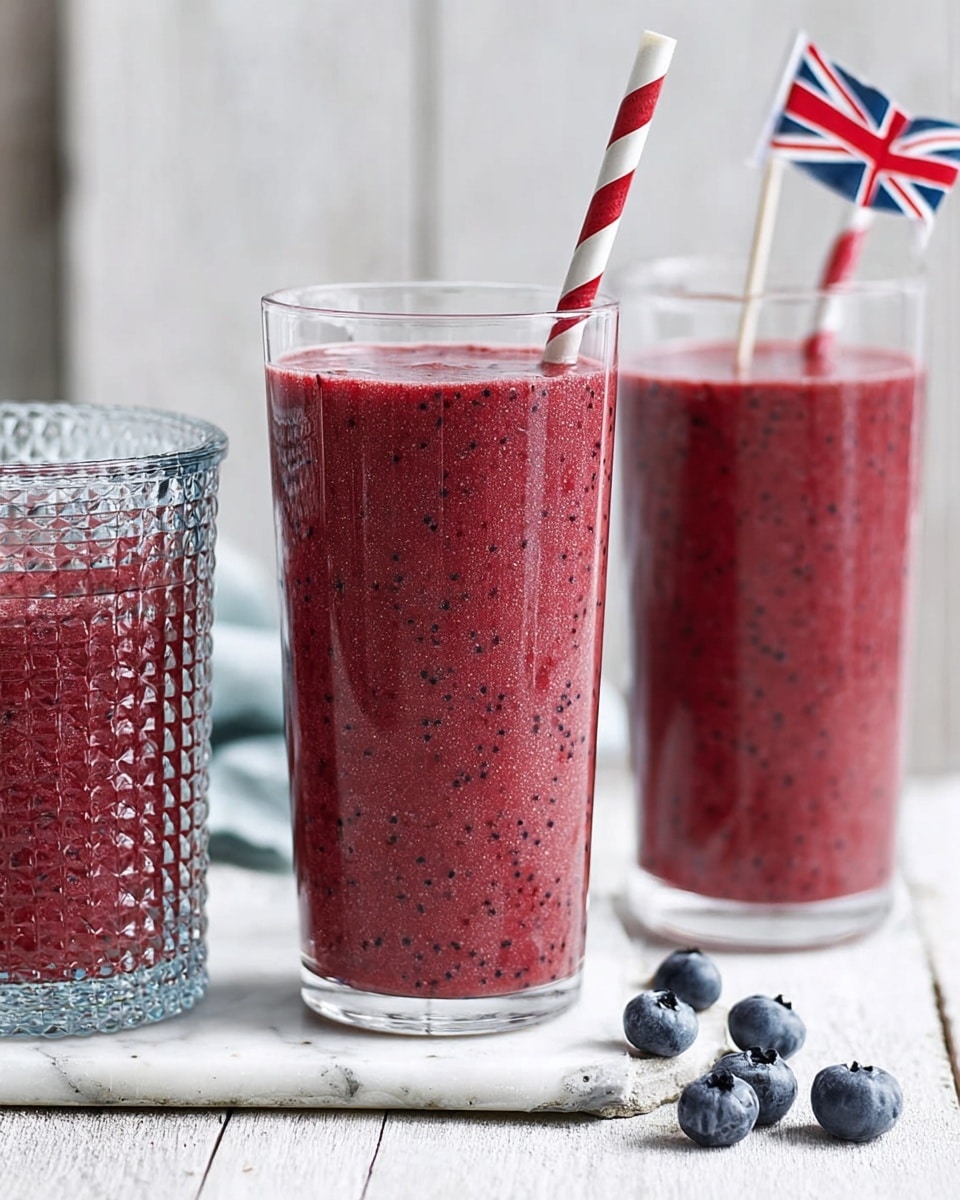The image shows three clear glass cups filled with a thick, dark purple smoothie with visible small berry seeds. The cups are of different heights, arranged from smallest on the left to tallest in the middle, and a textured cup on the right. The tallest and smallest glasses are without straws, while the textured cup has a red and white striped straw. A red and white striped straw lies on the white marbled surface in front, along with a few scattered blueberries. In the background on the right, a small British flag stick is placed next to a few loose blueberries, all set on a white marbled surface with a soft, light gray wooden panel background. photo taken with an iphone --ar 4:5 --v 7