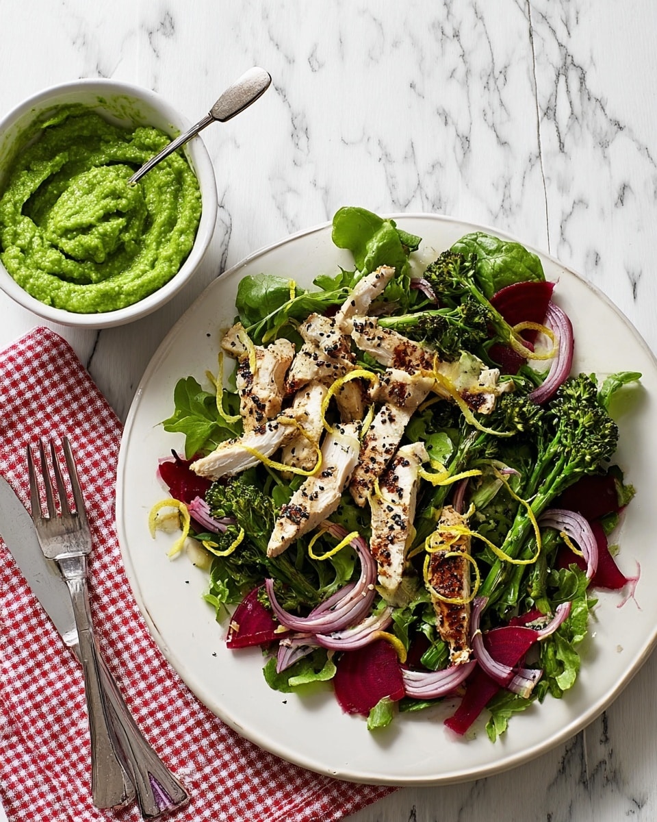A white plate holds a fresh salad with several layers: the bottom layer is thin, red beet sticks and light purple thinly sliced onions spread evenly. On top are bright green leafy greens and small broccolini pieces scattered around. Charred grilled chicken pieces with a light brown crust and black sesame seeds are placed over the greens. Thin yellow lemon zest curls are sprinkled on top. Next to the plate, a white bowl filled with thick, bright green pea puree with a spoon inside sits on a red and white checkered napkin, accompanied by a fork and knife. The background is a white marbled texture. photo taken with an iphone --ar 4:5 --v 7