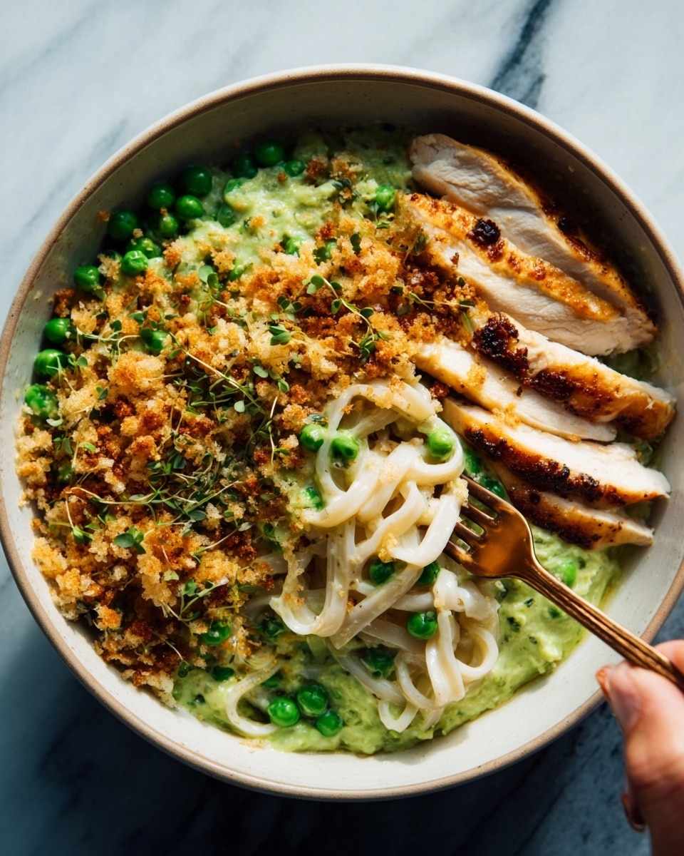 The dish is served in a white bowl filled with thick, light-colored udon noodles at the bottom, topped with a layer of green peas mixed in a creamy sauce, covering the left half of the bowl. On the right side, there are slices of cooked chicken breast, light brown with a slightly crispy texture. Above the chicken and noodles, there is a generous sprinkling of golden-brown toasted breadcrumbs mixed with finely chopped green herbs, giving a crunchy look. A woman's hand holding a gold fork is seen on the right side, reaching into the bowl. The bowl rests on a white marbled surface. Photo taken with an iphone --ar 4:5 --v 7