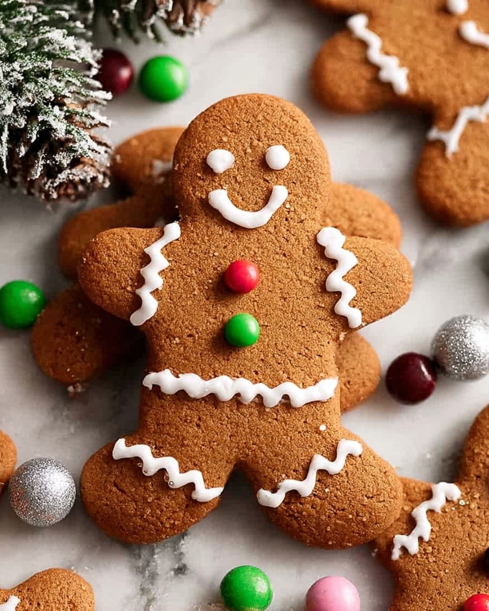 The image shows a gingerbread cookie shaped like a person standing upright at the center. The cookie is brown with a rough texture and decorated with white icing forming eyes, a smile, zigzag lines on the arms and waist. It has two small round candies on the chest, one green and one red. Around it, several similar gingerbread cookies lay flat on a white marbled surface, also decorated with white icing and multicolored candies. In the background, frosted pine cones and green pine leaves create a festive scene. Photo taken with an iphone --ar 4:5 --v 7