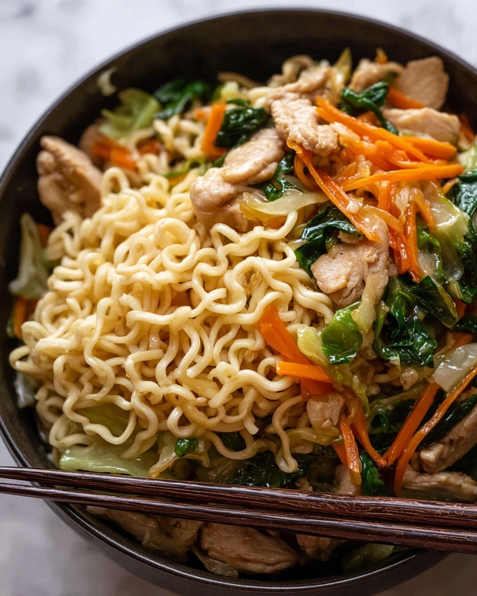 The dish shows a close-up of stir-fried noodles in a black bowl, filled with three main layers: tangled light yellow cooked noodles at the base, mixed with bright orange thin carrot strips and dark green leafy vegetables spread throughout, and topped with light brown strips of cooked chicken pieces scattered evenly. The noodles have a glossy texture, and the vegetables look fresh and slightly wilted. A pair of wooden chopsticks rests on the side of the bowl, adding depth to the image, all set against a white marbled surface. Photo taken with an iphone --ar 4:5 --v 7