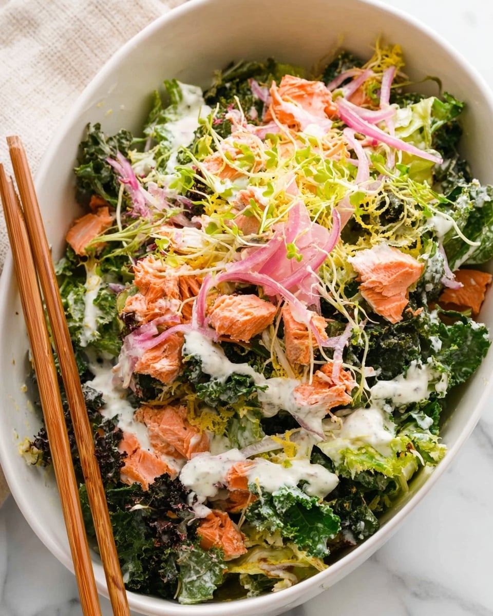 A white bowl filled with a fresh salad made up of several layers starting with a base of dark green kale and lighter green romaine lettuce leaves, topped with medium-sized, flaky pieces of cooked salmon in a light orange-brown color. There are thin, bright pink pickled onion slices scattered throughout. On top, green pea shoots add a touch of light green with their delicate, thin stems. The whole salad is drizzled with a creamy white dressing, and grated pale yellow cheese is sprinkled over the top, creating a mix of soft, crunchy, and creamy textures. The bowl rests on a white marbled surface, and wooden chopsticks are placed on the side. photo taken with an iphone --ar 4:5 --v 7